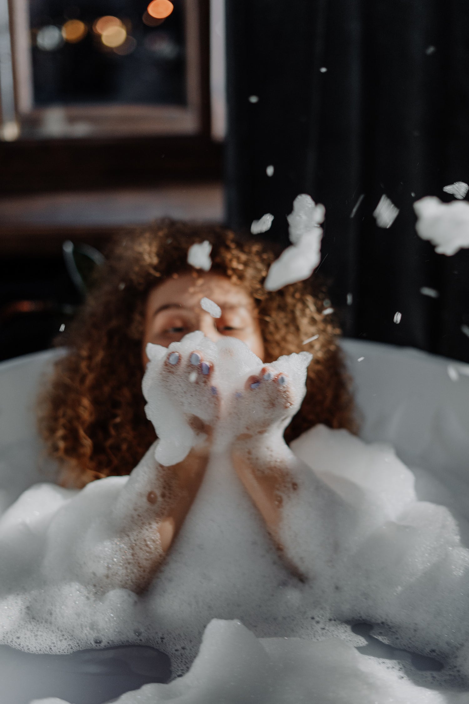 photo by Cottonbro Studio - Image of woman in a bathtub blowing bubbles from her hands.
