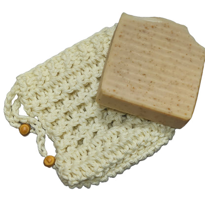 off whte hand crochet cotton soap bag with decorative wood beads shown with oat n honey natural bar soap - soap sold seperately