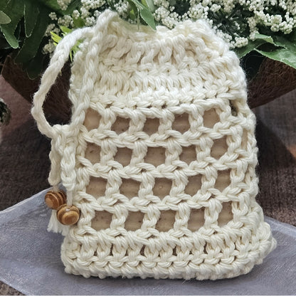 off white hand crochet cotton soap bag with decorative wood beads shown with bar soap and packaging - soap sold seperately