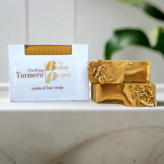 branded clarifying turmeric soap box next to a two bar stack of turmeric soap